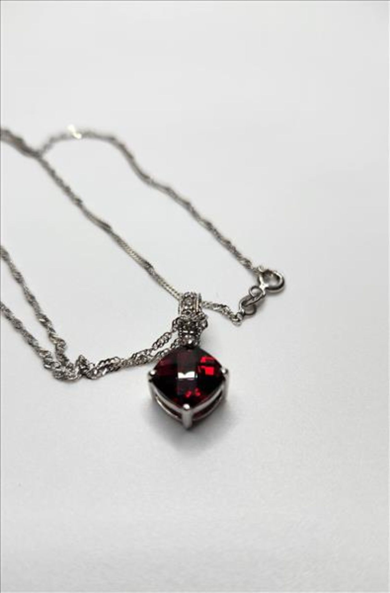 One lady’s stamped 14kt white gold Garnet and diamond pendant and 10kt white gold chain. Contained - Image 4 of 5