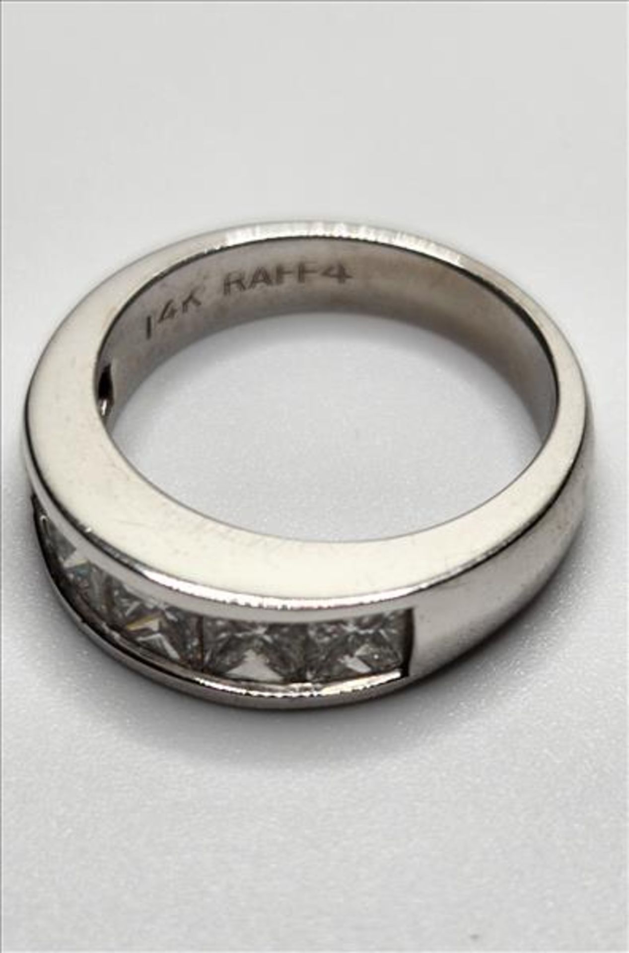 One lady’s stamped and tested 14kt white gold (Raff-4) diamond band shaped ring. Channel set