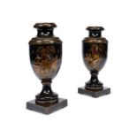 A pair of late 19th century black japanned chimney urns