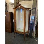 A late 19th century Louis XV style walnut carved serpentine vitrine