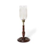 A Regency mahogany and gilt brass candlestick with glass storm shade