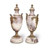 A pair of late 19th / early 20th century Louis XIV style gilt-bronze mounted marble urns