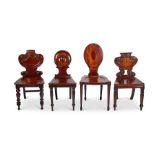 A group of four assorted Georgian mahogany carved hall chairs