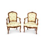 A pair of 19th century French Louis XV style walnut carved fauteuils / open armchairs