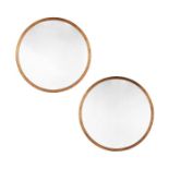 A pair of Tom Faulkner antiqued brass circular ‘Madison’ wall mirrors