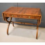A reproduction mahogany sofa table with two drawers and raised on brass castors.72cm high