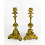 A pair of 19th century gilt metal candlesticks, the candle sockets cast with rams heads, 27cm high.