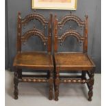 A pair of Derbyshire Oak side chairs, with carved curved back rails and spindles.