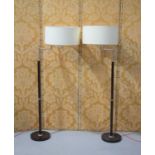 A pair of modern contemporary style lamp standards with cream shades