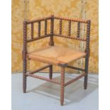 A late 19th century bobbin turned oak corner chair with rush seat