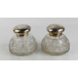 A pair of large cut glass and silverplate dome form inkwells.