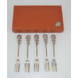 A set of five continental silver cake forks with engraved decoration and rose flower handles.