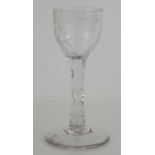 A 19th century sherry glass with faceted stem and engraved with a bird and a flower.