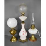 Three paraffin lamps, one in brass with glass opaque shade, one converted to electric, and another