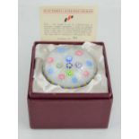 A limited edition Perthshire PP11 glass millefiori paperweight, multiple florettes on white