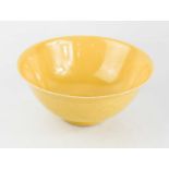 A Chinese porcelain yellow glazed bowl, impressed with decoration to the body, and having blue six