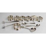A group of silver to include a set of six silver napkin rings with beaded edges, a pair of sugar