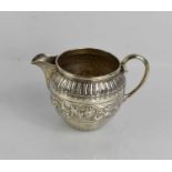 A silver jug, embossed with scrollwork and reeded rim, 3.9g.