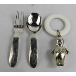 A silver christening spoon and fork, engraved with nursery rhyme figures, together with a