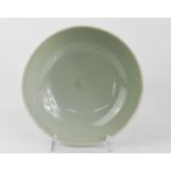 A Chinese green celadon glazed bowl, with impressed decoration to the body, 17cm diameter.