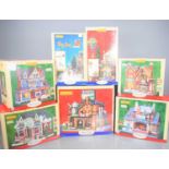 A group of boxed Lemax village buildings to include the Holly Jolly Christmas shop, Medford glass