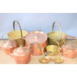 A collection of copper and brass wares, including two large brass jam pans, and a very large oval