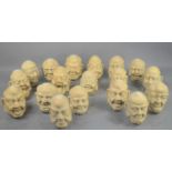 A collection of eighteen Chinese stoneware sage heads, each with grotesque expressions. (18)