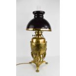 An Edwardian brass paraffin lamp with domed opaque glass shade, converted to electricity, the