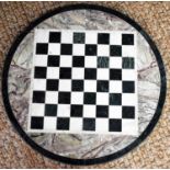 An antique marble and slate chess board table top, 60cm diameter.