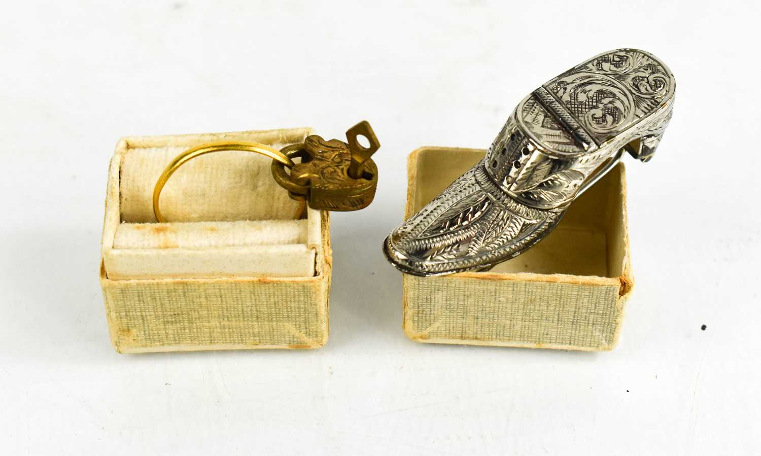 An 18ct gold ring indistictly hallmarked, a lock and key pendant and a silver shoe form snuff box