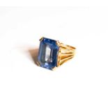 A gold dress ring set with emerald cut blue stone, likely topaz, 16.8 by 12.4mm, ring size J, 7.04g,