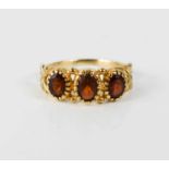 A 9ct gold vintage garnet three stone ring, size M½, 2g.