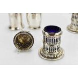A pair of Georgian silver pepper pots of decorative pierced cylindrical form on circular bases,