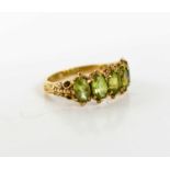 A 9ct gold and peridot five stone ring, each of the oval cut stones approximately 6.0 by 4.5mm, size