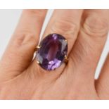 A 9ct gold and amethyst dress ring, the oval cut amethyst of approximately 19.6 by 15mm, in basket
