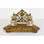 An early 20th century brass desk stand, with two original glass inkwells, the raised back ornately