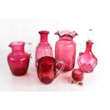 A group of antique cranberry glass to include oil jar and stopper, two jugs, a carafe, salt and a