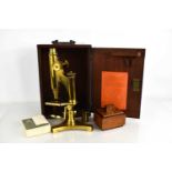 An R&J Beck brass monocular microscope in original mahogany case with key.