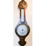 A 20th century wheel barometer, the case carved with decoration.