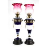 A pair of neo-classical Continental porcelain oil lamps of conical form, cobalt blue ground with