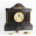 A Victorian slate mantle clock with Roman numeral dial flanked by decorative columns.