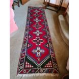An antique wool Middle Eastern runner, with quatreform motifs.