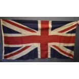 A vintage linen Union flag of separate panels of red, blue and cream, stitched together to form