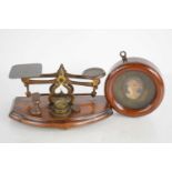 A set of small postal scales with five weights on a wooden base, together with a coloured cameo in