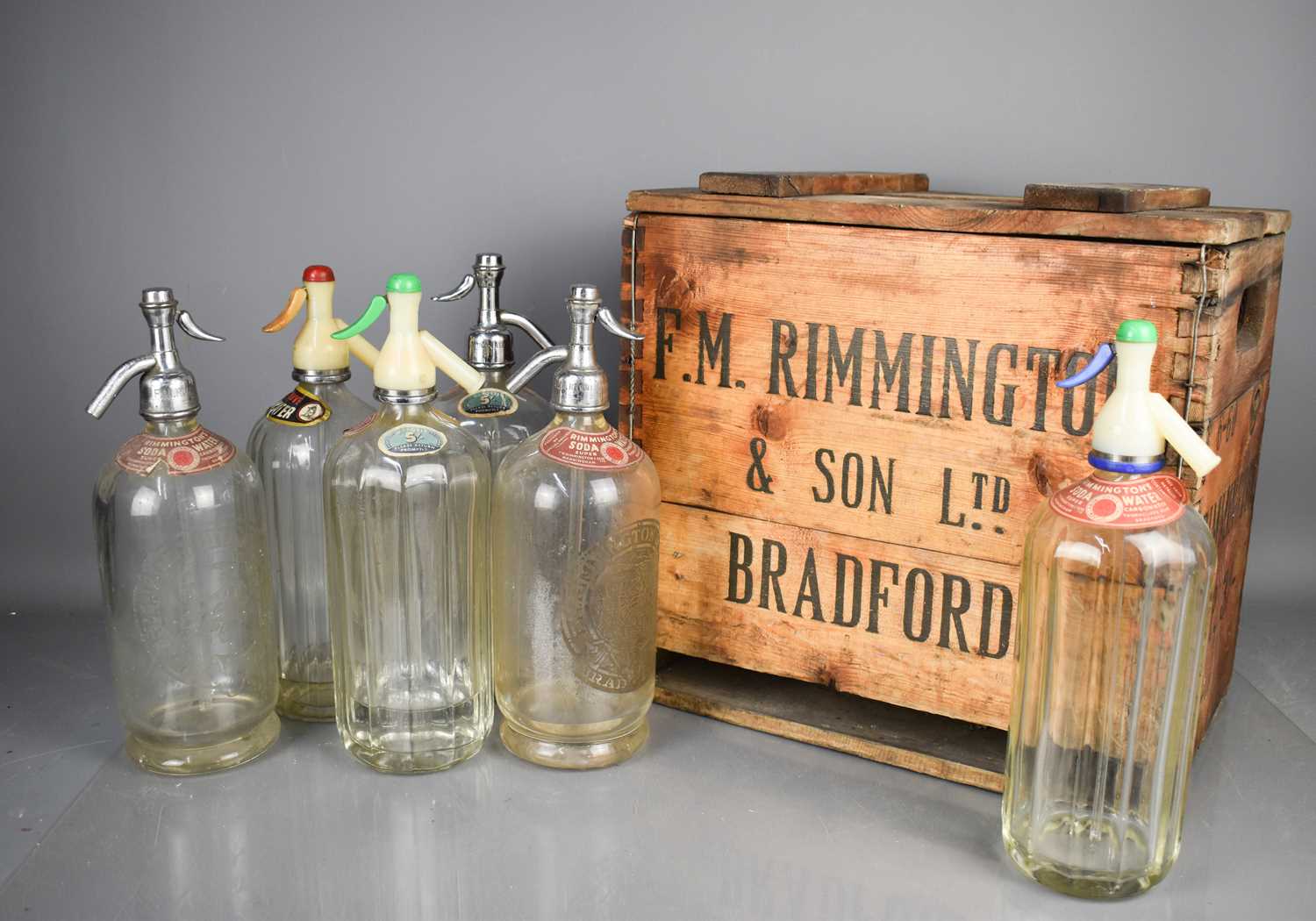 A F.M Rimmington & Son Ltd wooden crate containing six Rimmingtons Soda Water bottles.