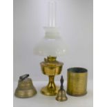 A brass Aladdin oil lamp with glass shade and chimney together with a brass shell and bronze bell.