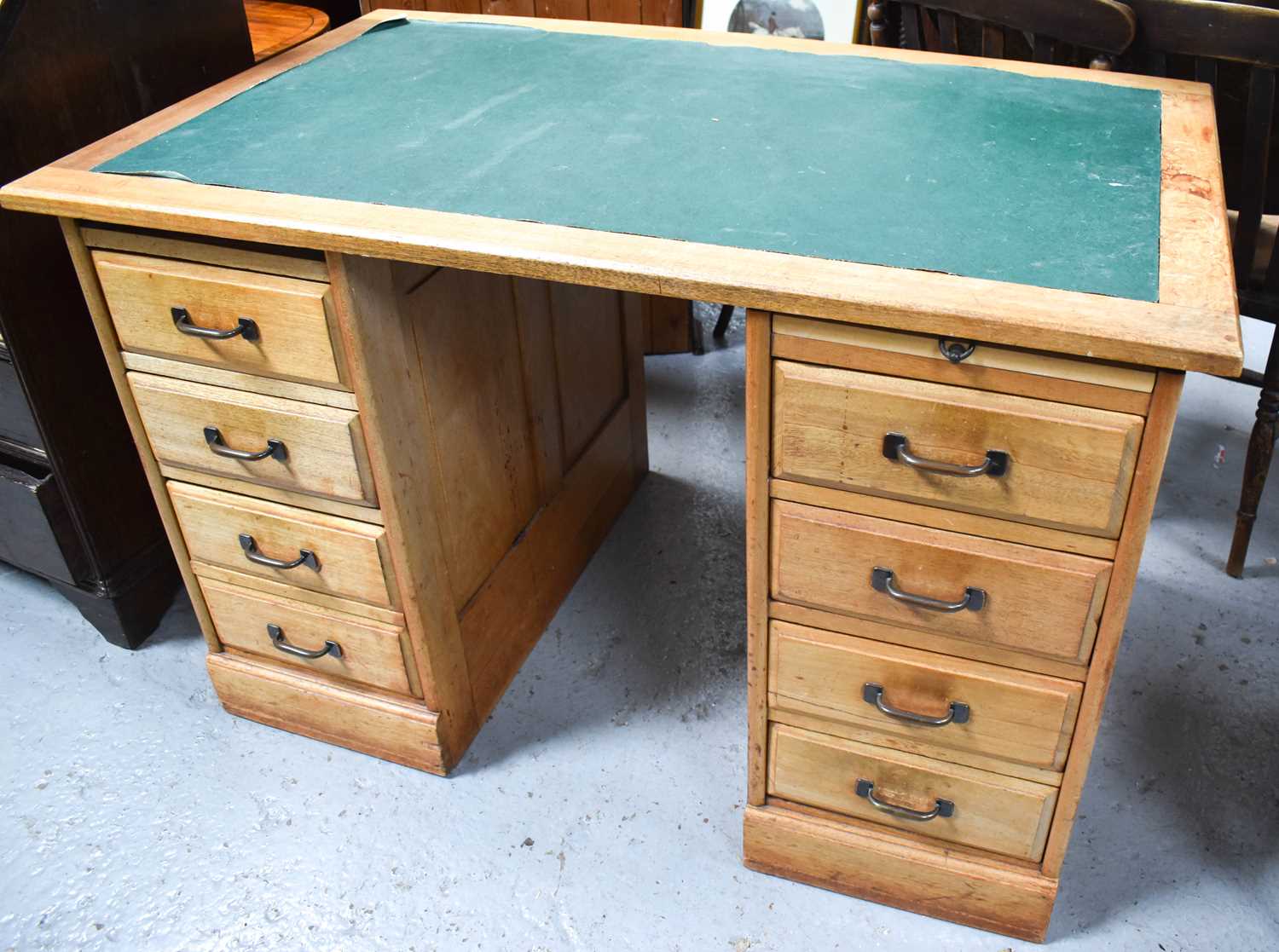 A 1970s twin pedestal desk with two banks of four drawers and bronze handles with green vinyl top,