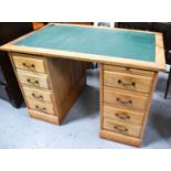 A 1970s twin pedestal desk with two banks of four drawers and bronze handles with green vinyl top,