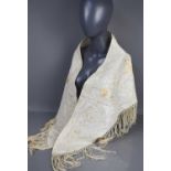 A shaped ivory coloured Chinese shawl, Qing dynasty, embroidered in cream silks with