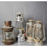 A copper ships lantern together with three other lanterns.